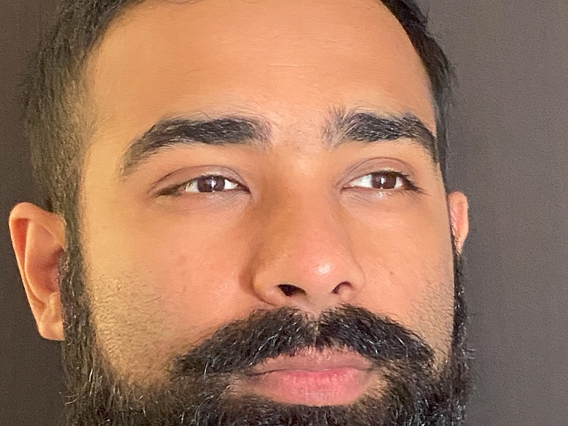 Akhil standing in front of a brown background