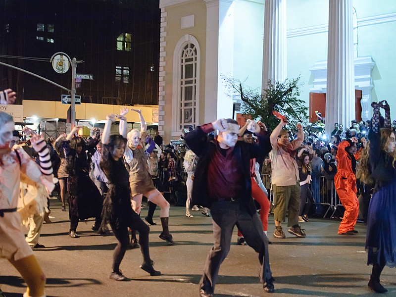Costumed people on the street at a Halloween parade.