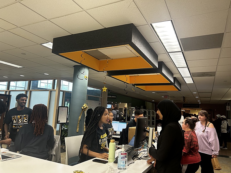 Students working at the Academic Success Center's front desk, checking guests in for tutoring appointments