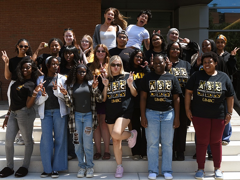 Group of students posing together in front of a building.