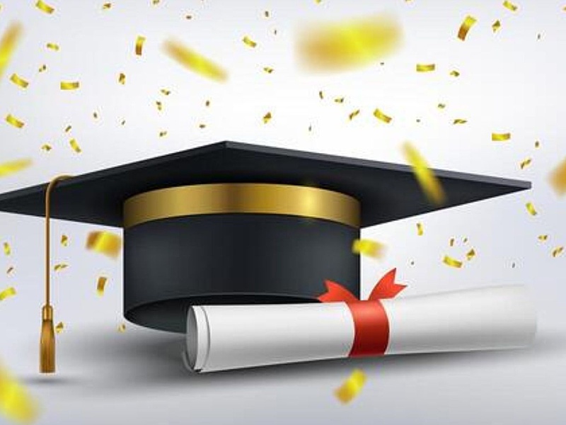 Graduation cap and diploma with gold confetti falling around it.