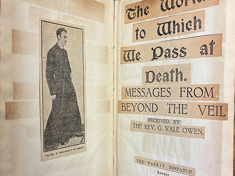 Open book page spread showing pasted in newspaper clippings