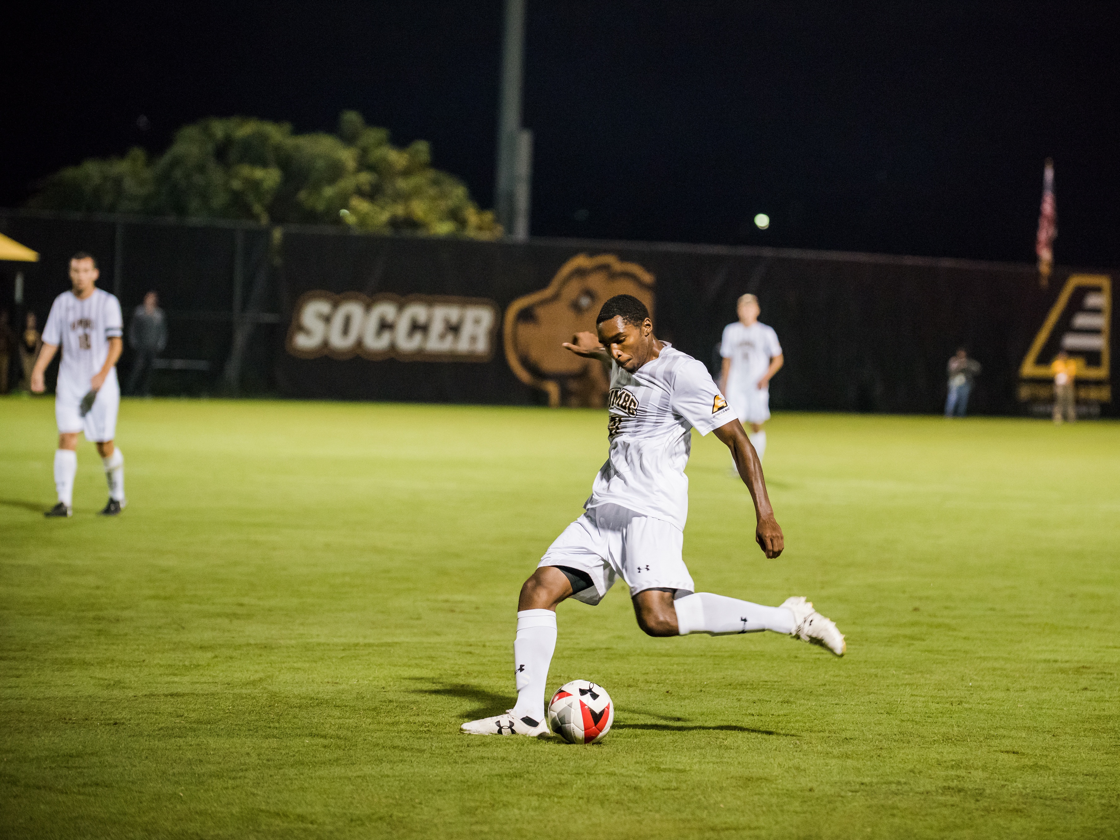 UMBC Men's soccer player getting ready to kick a soccer ball during a game.