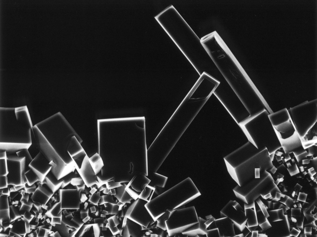 In an abstract looking black and white photo, crystal forms are stacked on top of one another.